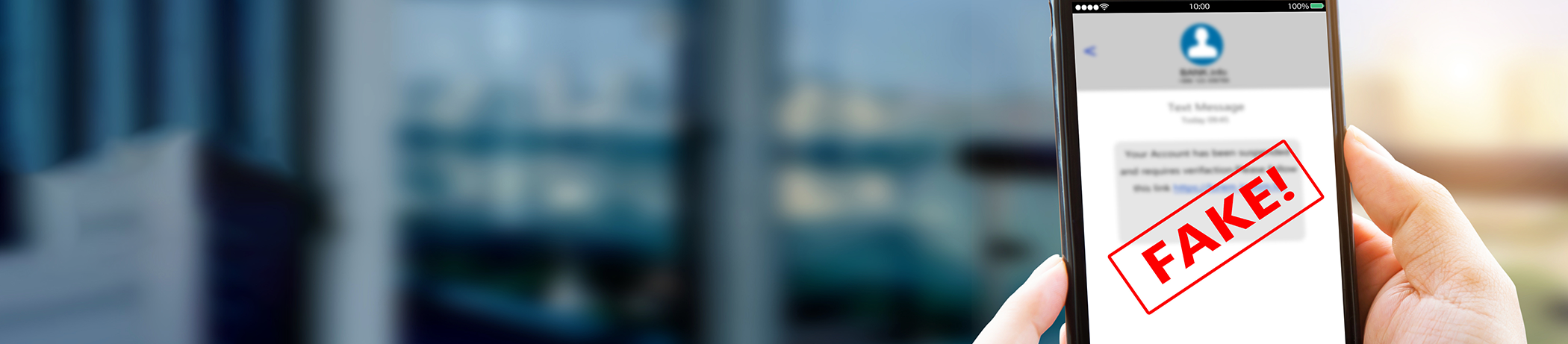 Scam Prevention - man holding phone with the word FAKE on it